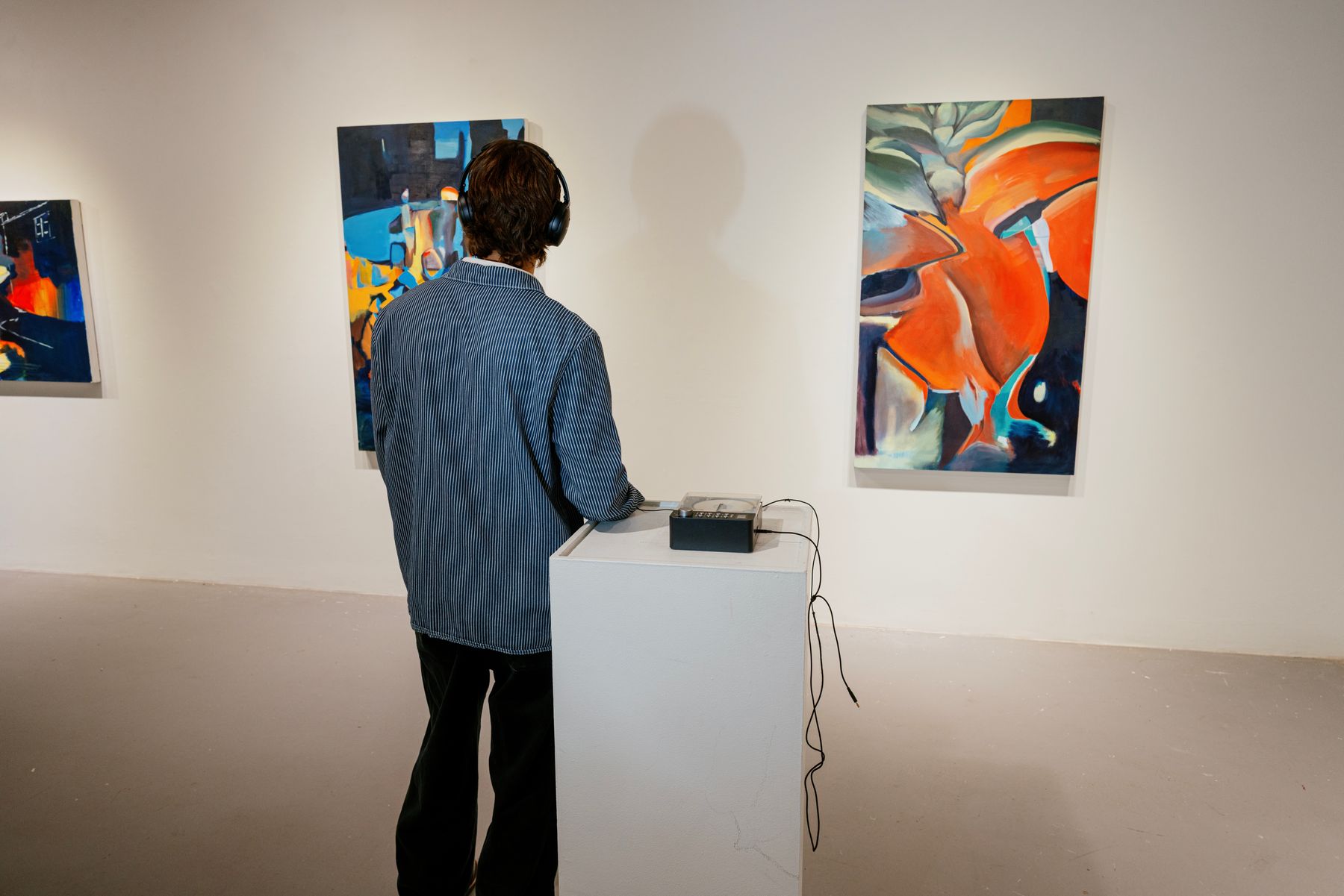 A visitor alone at the listening station with headphones on